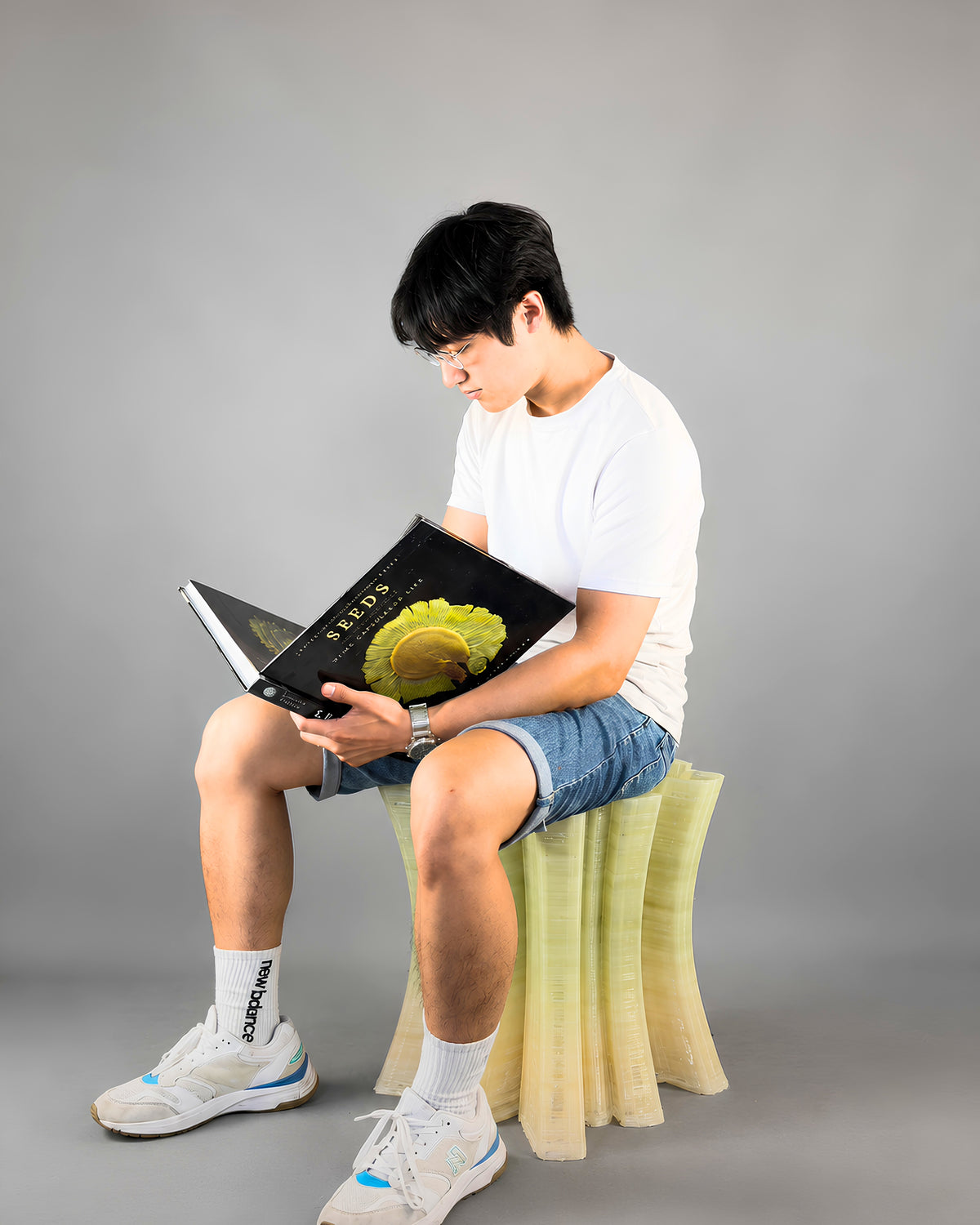 Designer Chao-Chun Kung seated on a translucent bio-composite 3D-printed stool from the After the Last Sip collection.