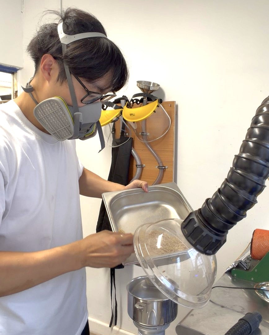 Designer Chao-Chun Kung preparing tea and coffee waste for material compounding at Fab.Pub while wearing respiratory protection.