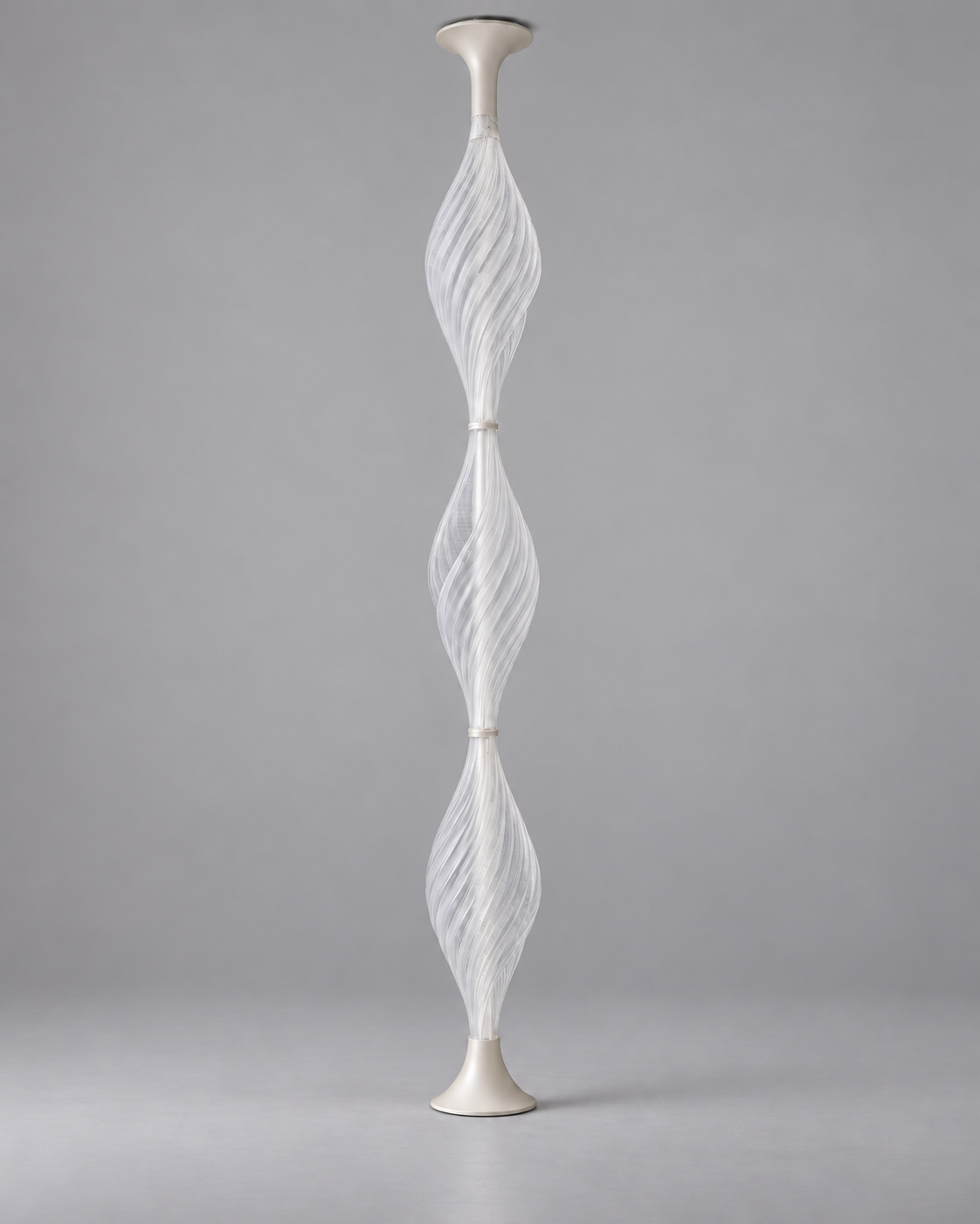 Pupa Trio with its light switched off, showing translucent spiral forms on a grey studio background. AI-assisted visualisation.